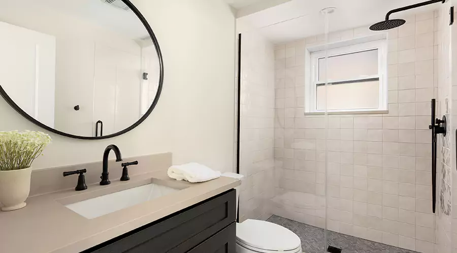 Modern master bathroom renovation featuring grey double vanity, chrome fixtures, and white marble tile walk-in shower